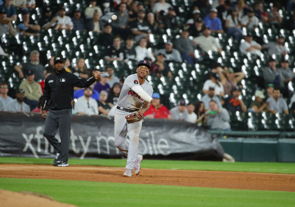 Rafael Devers makes a throw to first base. His defense is much improved.