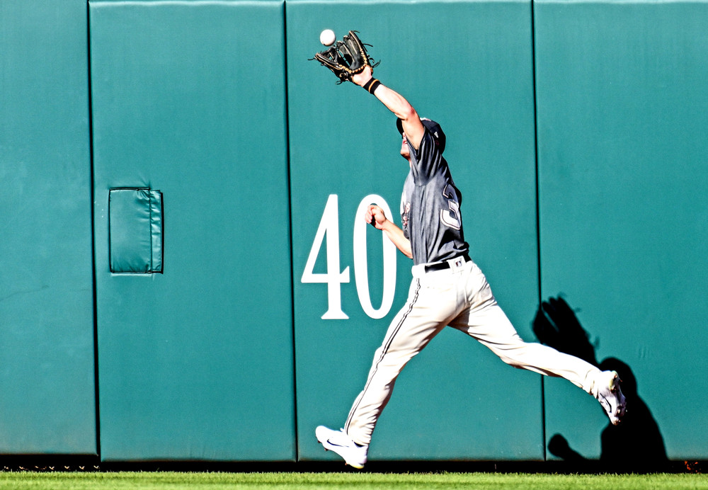 Jacob Young prepares to make a catch at the outfield fence.