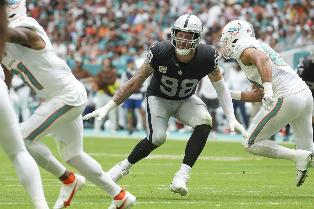 Maxx Crosby stands, knees bent, as he defends near the line of scrimmage