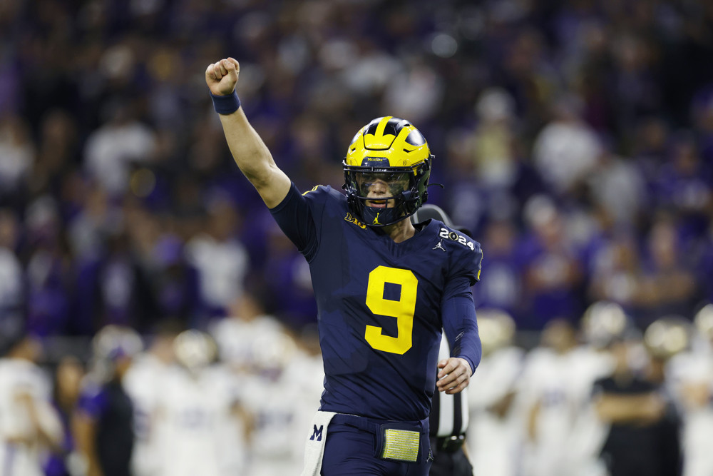 J.J. McCarthy raises his fist to call a play.