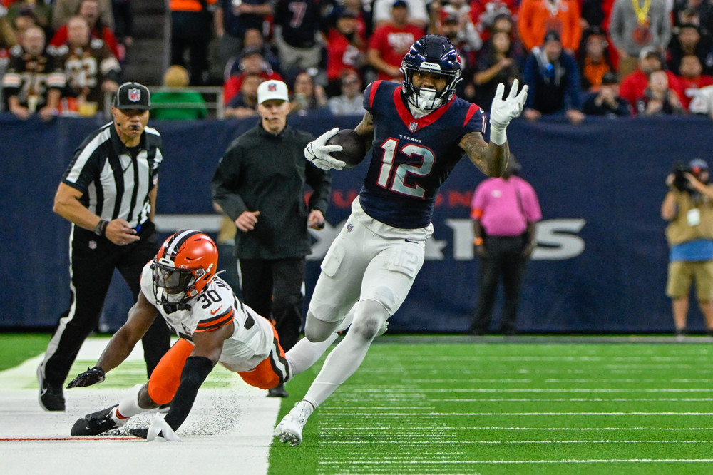 Nico Collins runs upfield after avoiding a tackle.