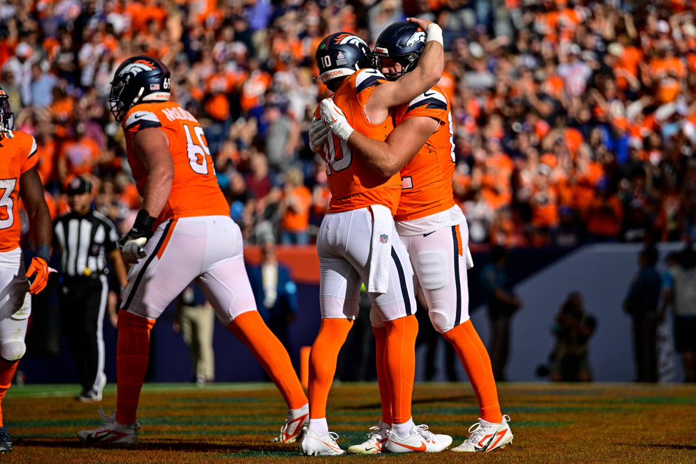 Broncos quarterback Bo Nix (10) and tight end Adam Trautman celebrate with a hug