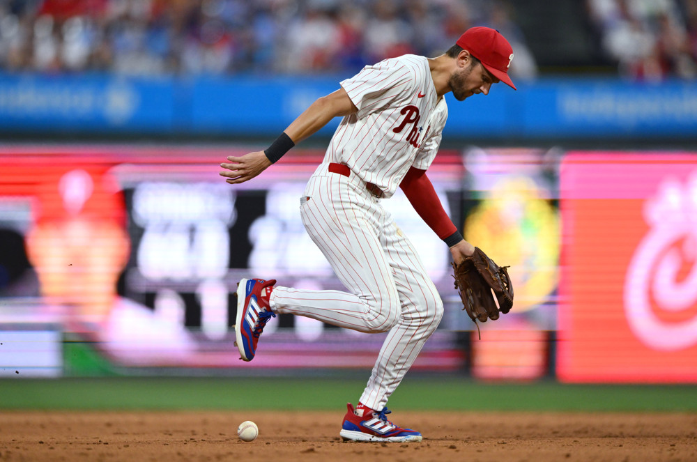 Treat Turner looks down at a ball that he misplayed at shortstop.